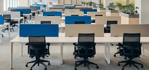 Modern open-plan office space featuring clean workstations, ergonomic chairs, and sanitized carpets provided by professional office cleaning services in San Diego, CA.
