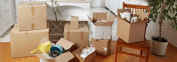 Packed moving boxes and household items in a kitchen before move-out or move-in cleaning, San Diego, CA.